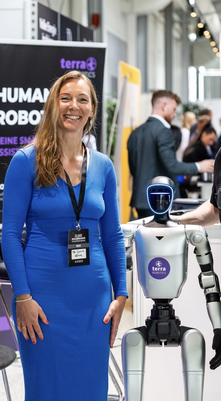 Dr. Julia König neben einem humanoiden Roboter von terra Robotics